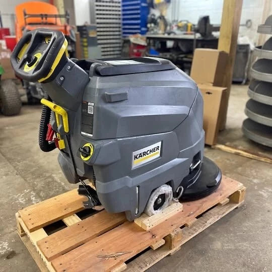 Front view of a Karcher BD 50/50 C Bp Classic floor scrubber showing the handle and controls on a pallet