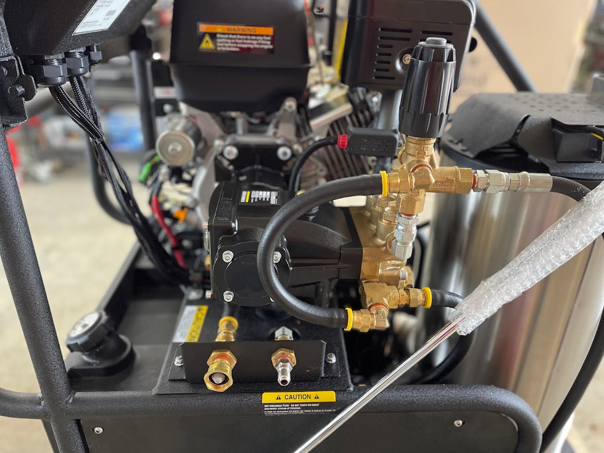 Close-up of the pump manifold, brass fittings, and inlet-outlet ports on the Kärcher LFT Cage pressure washer